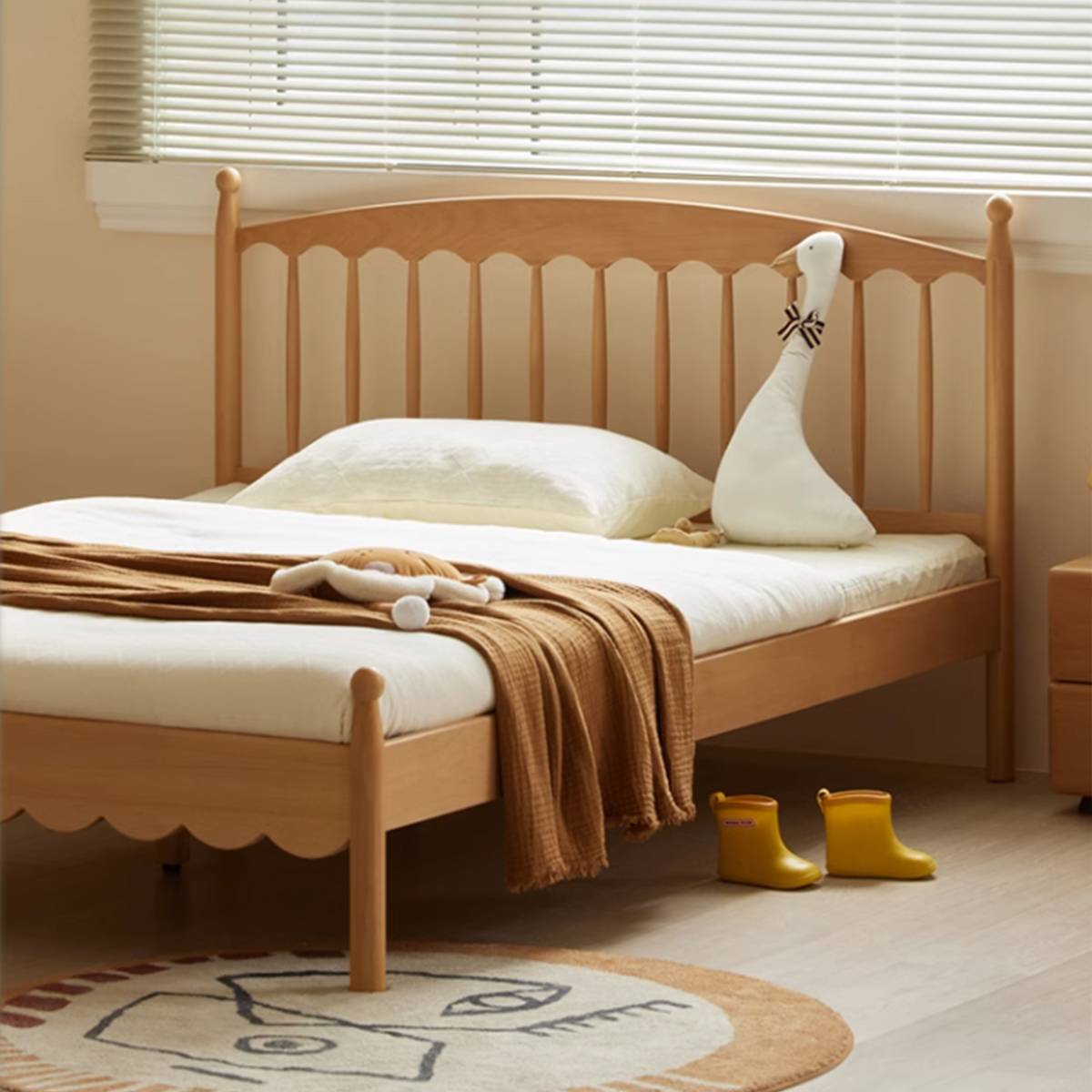 Side angle view of the Aile Windsor bed showing the scalloped footboard and yellow boots on the floor