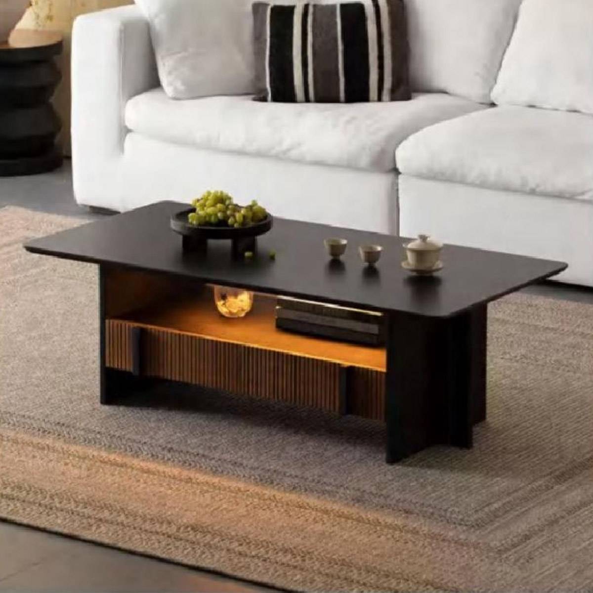 Front view of the coffee table in a living room setting with a white sofa, displaying a fruit bowl and tea set
