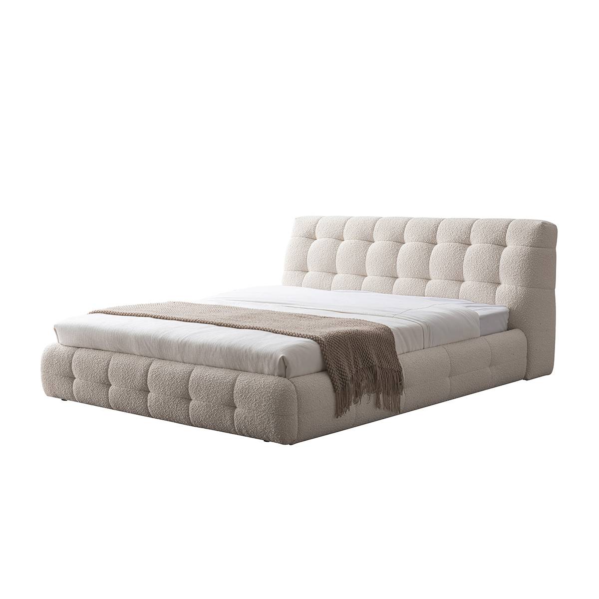 Angled view of the upholstered bed showing the headboard and base