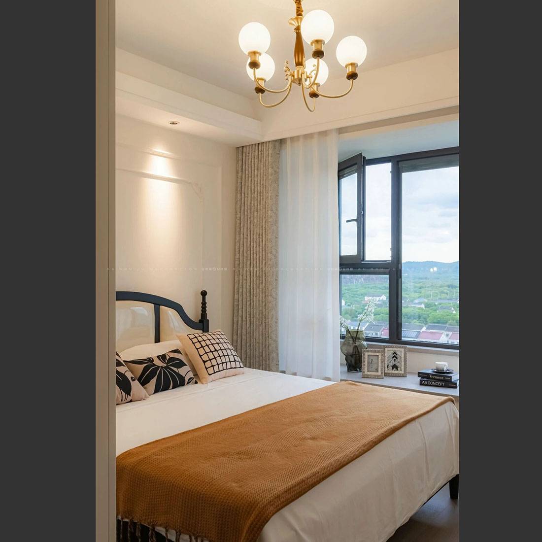 Bedroom interior with a bed, chandelier, and window view