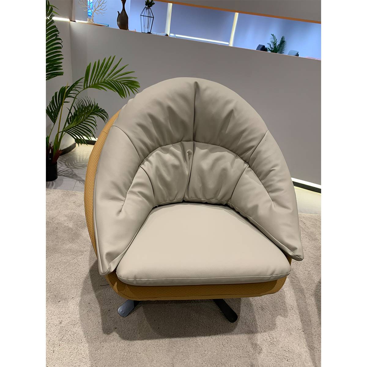 Close-up of beige leatherette swivel lounge chair showing cushion details