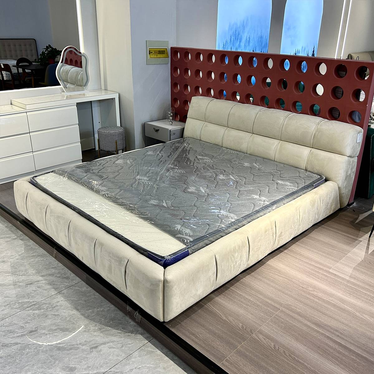 Front view of the beige upholstered puff bed showing the mattress and tufted headboard