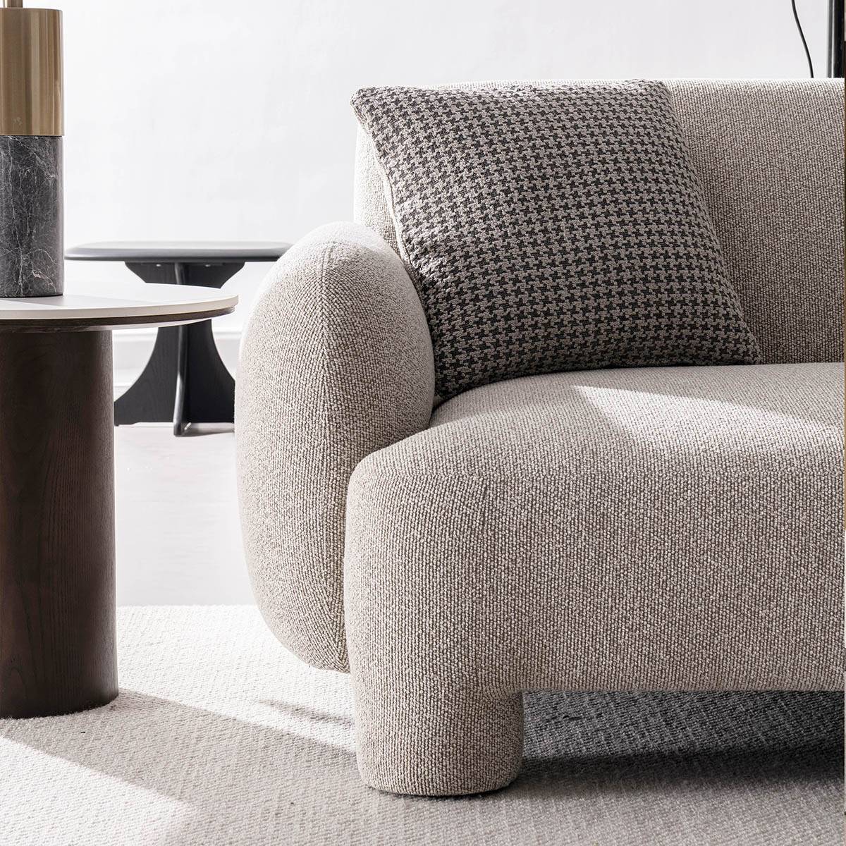 Close-up detail of the sofa armrest and houndstooth cushion