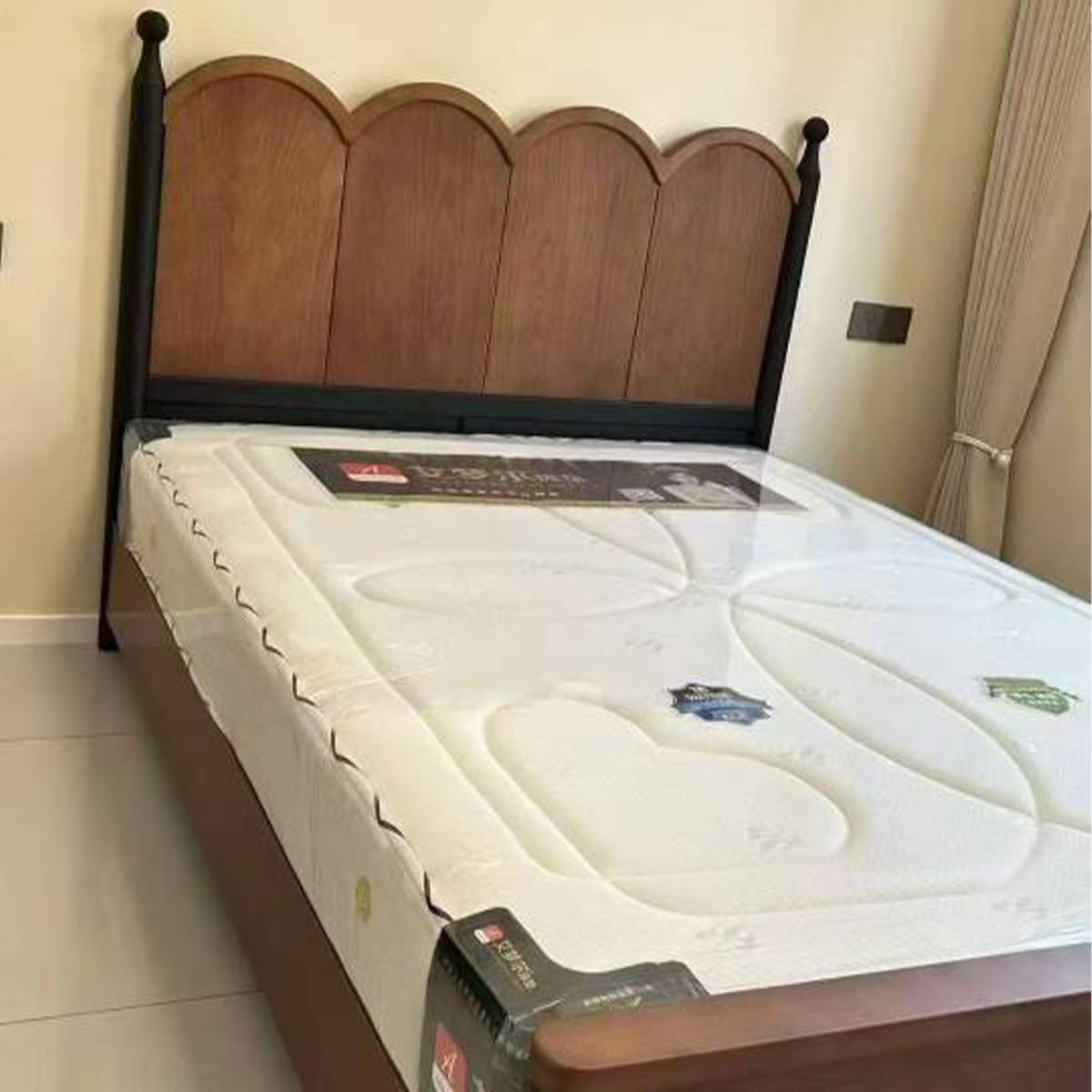 Close-up view of the bed frame with a mattress placed on top, highlighting the headboard design.