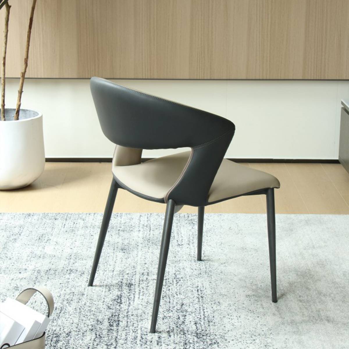 Side profile view of the dining chair showing the curved backrest and two-tone upholstery