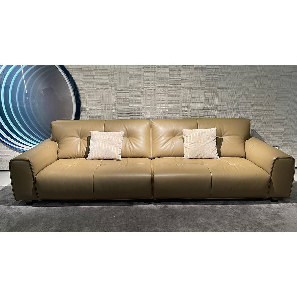 Front view of the leather sofa showing seat cushions and pillows