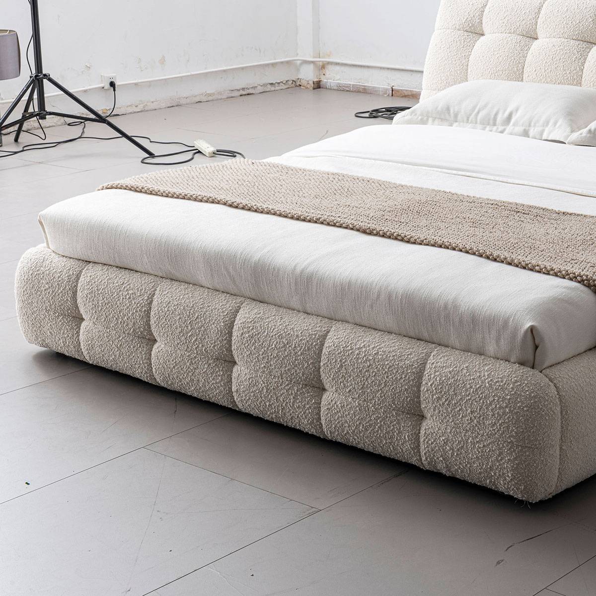 Side view of the upholstered bed frame showing the tufted base