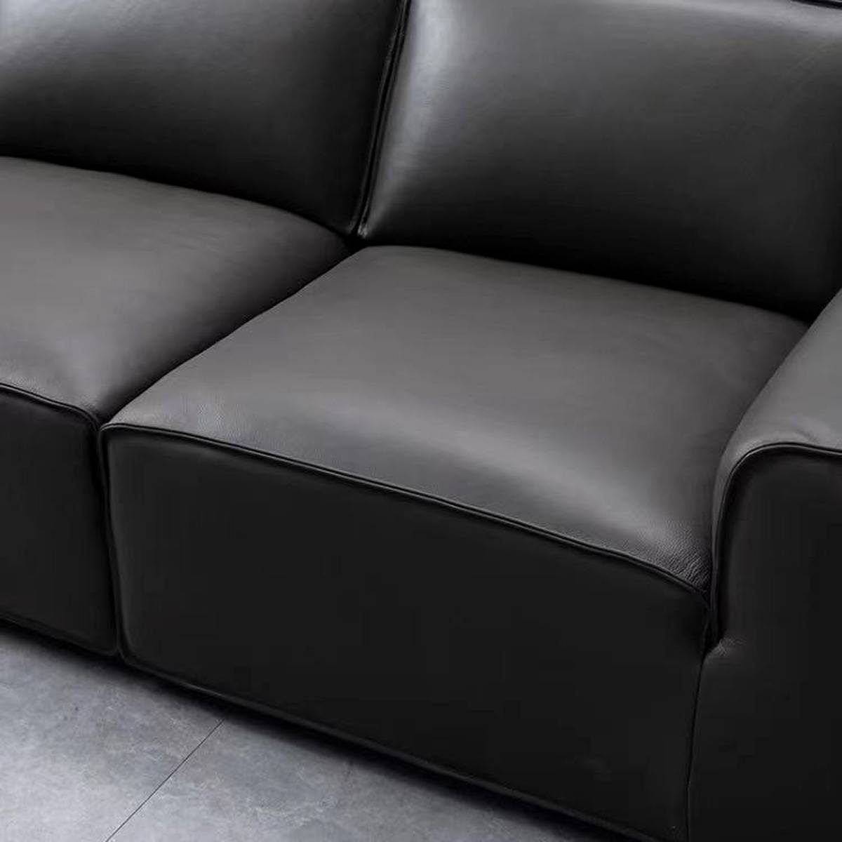 Close-up detail of the black leather seat cushion and armrest