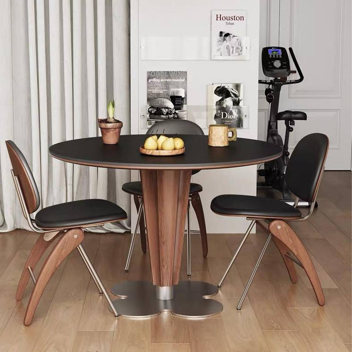 Black round dining table with fruit and decor in a modern interior