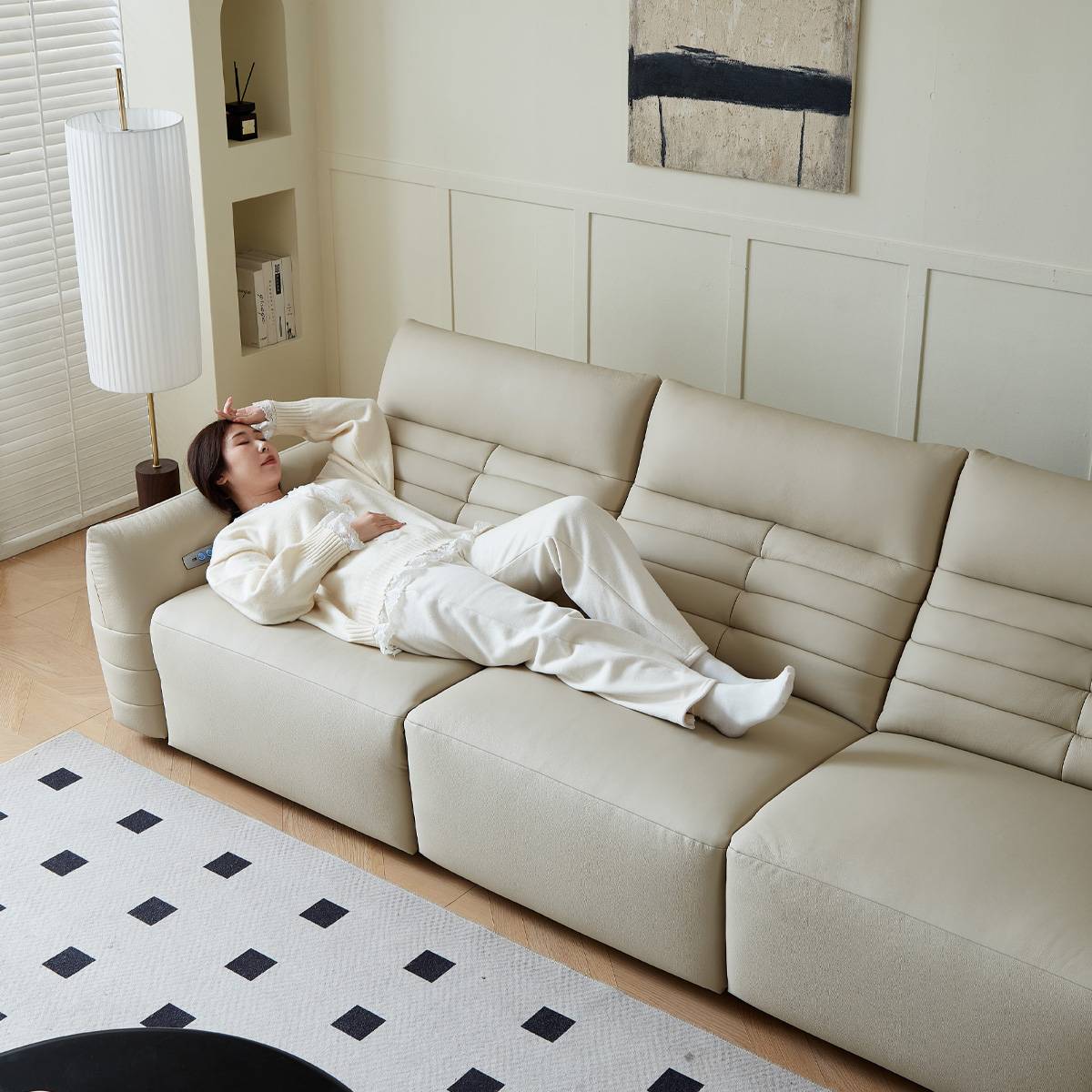 Person relaxing on the beige leather sofa, demonstrating comfort and space