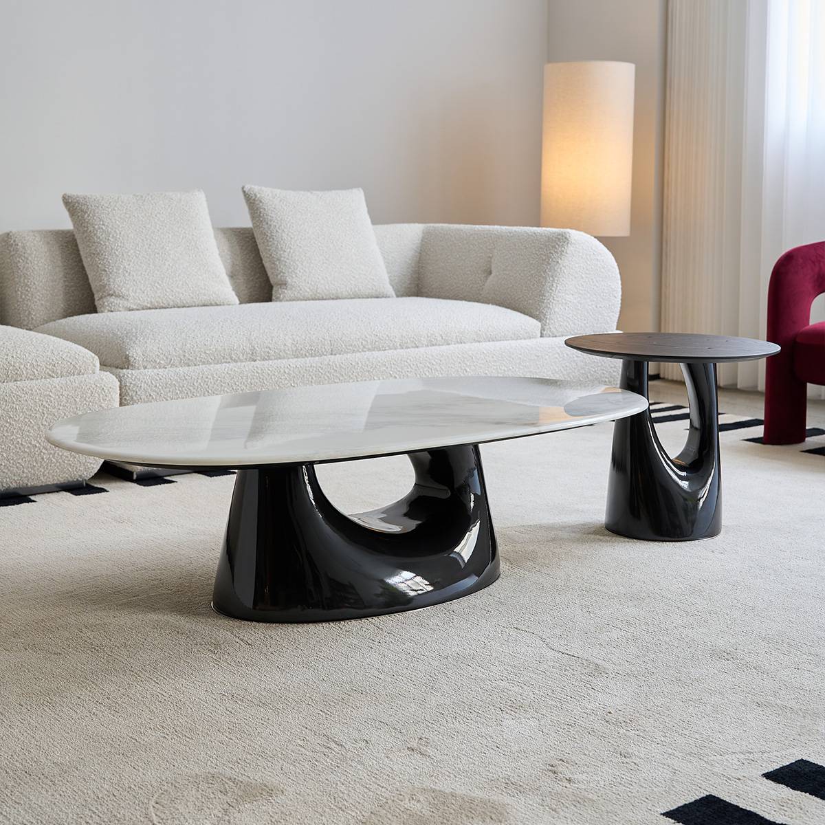 Full view of the oval coffee table with white stone top and black base in a living room setting