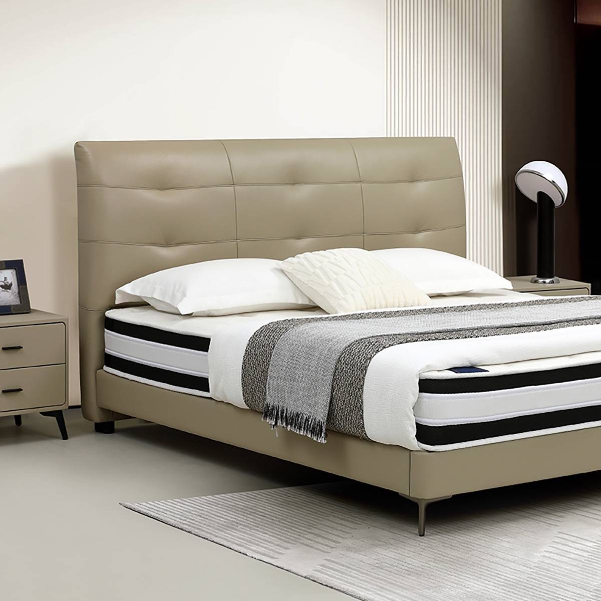 Side angle view of the leather bed showing the headboard and bedding