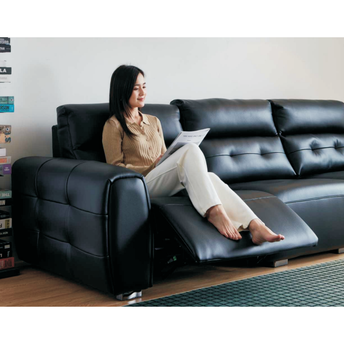 Close-up of the woman sitting on the reclining section of the sofa