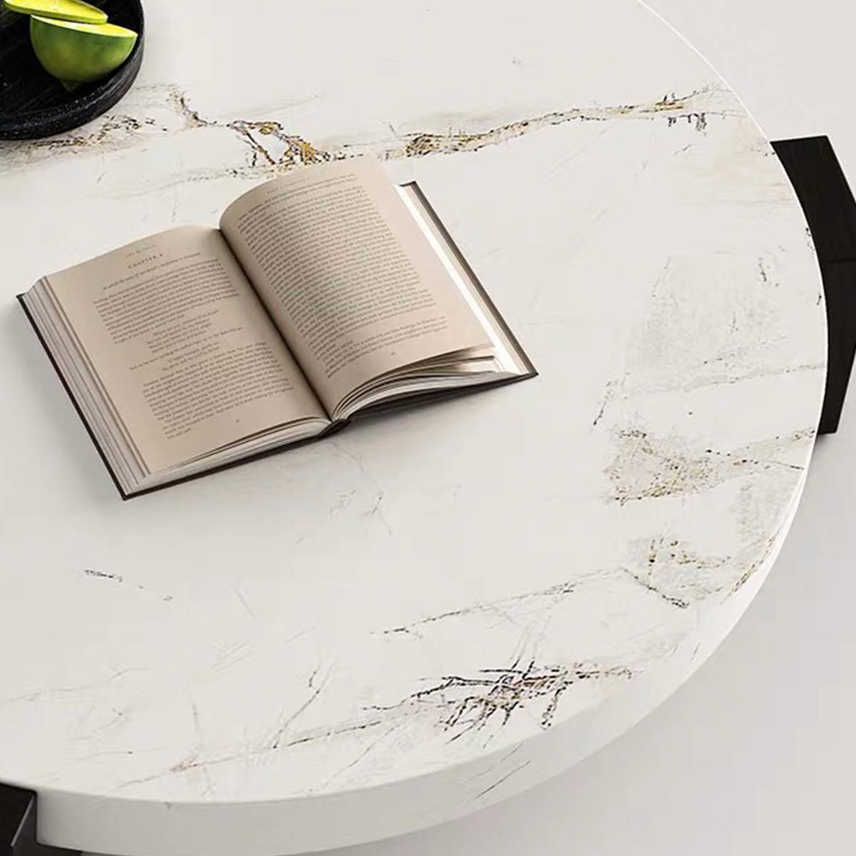 Top-down view of the round marble coffee table with an open book