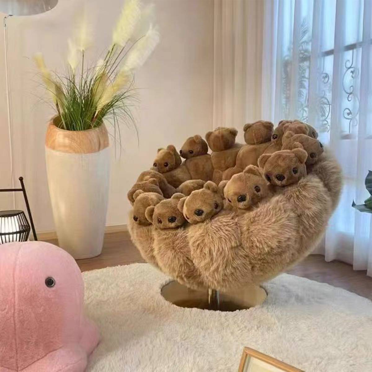 Close-up of brown bear lounge chair with pink elephant toy
