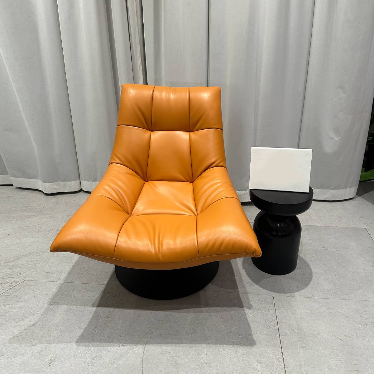 Front view of orange lounge chair showing tufted design
