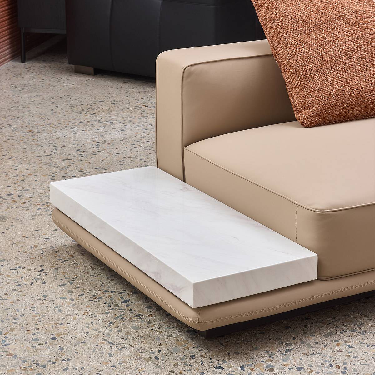 Close-up detail of the integrated white marble side table attached to the sofa arm