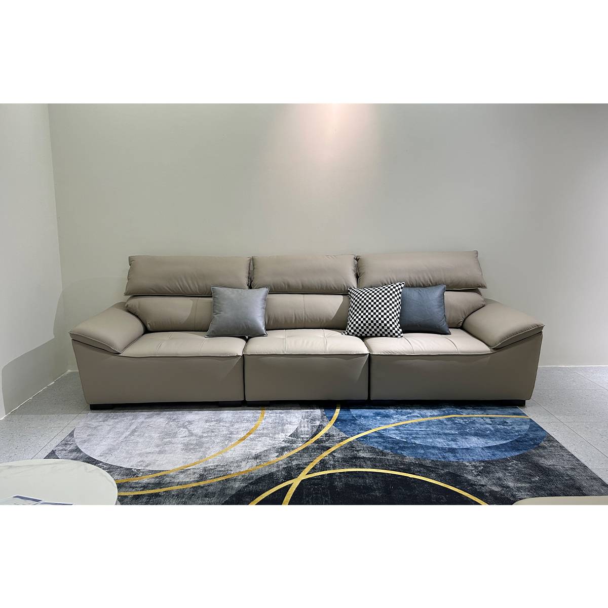 Front view of a beige straight sofa with three seat cushions and decorative throw pillows on a patterned rug.