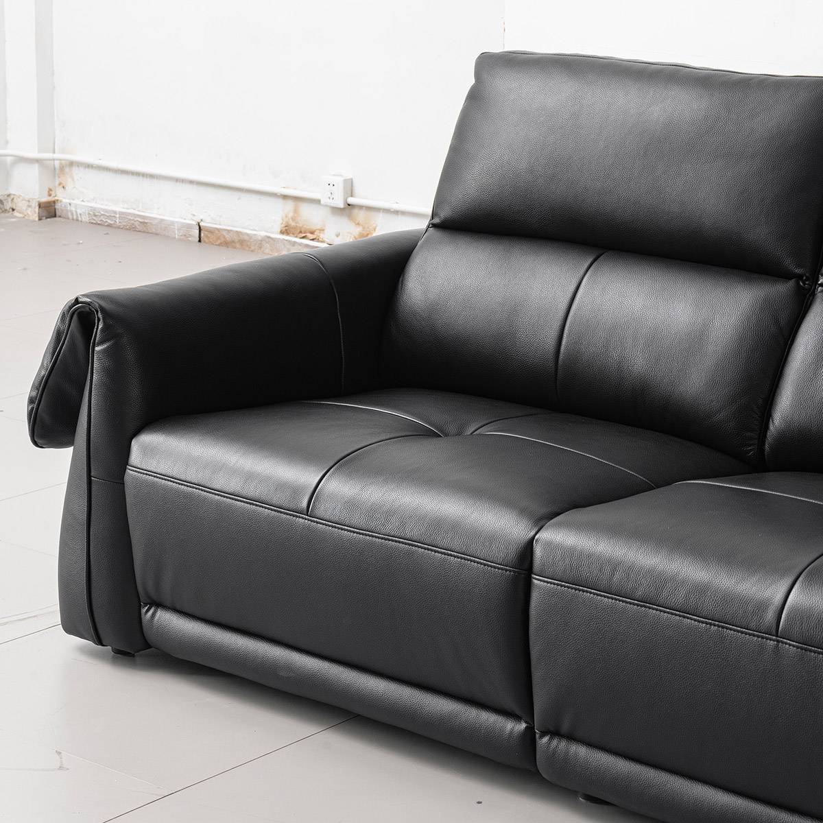 Close-up of the black leather sofa seat and armrest