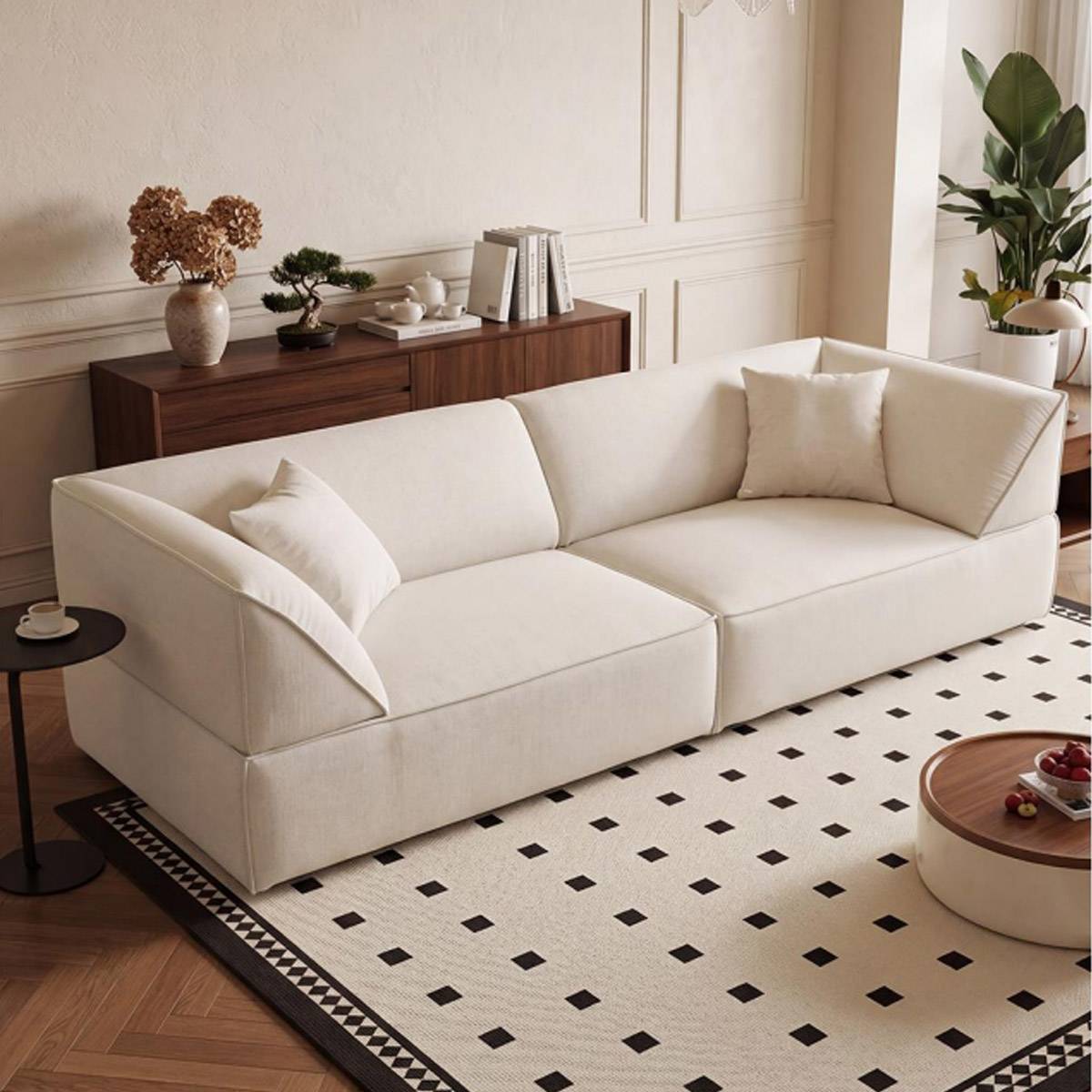 White fabric sofa in a living room setting with a patterned rug and side table