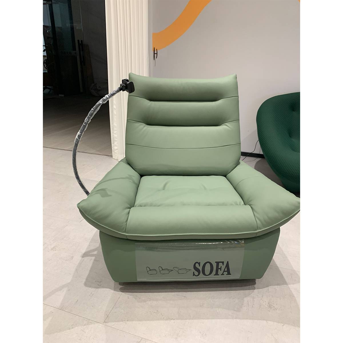 Front view of the light green lounge chair showing the seat cushion, backrest, and base with 'SOFA' label.