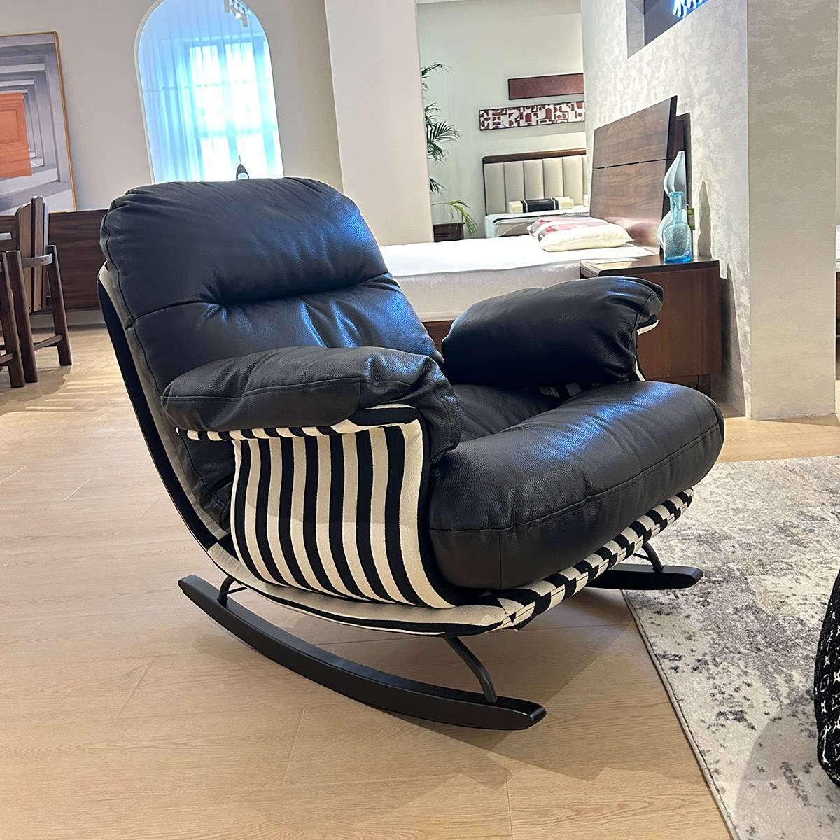 Black leather rocking chair placed in a bedroom setting