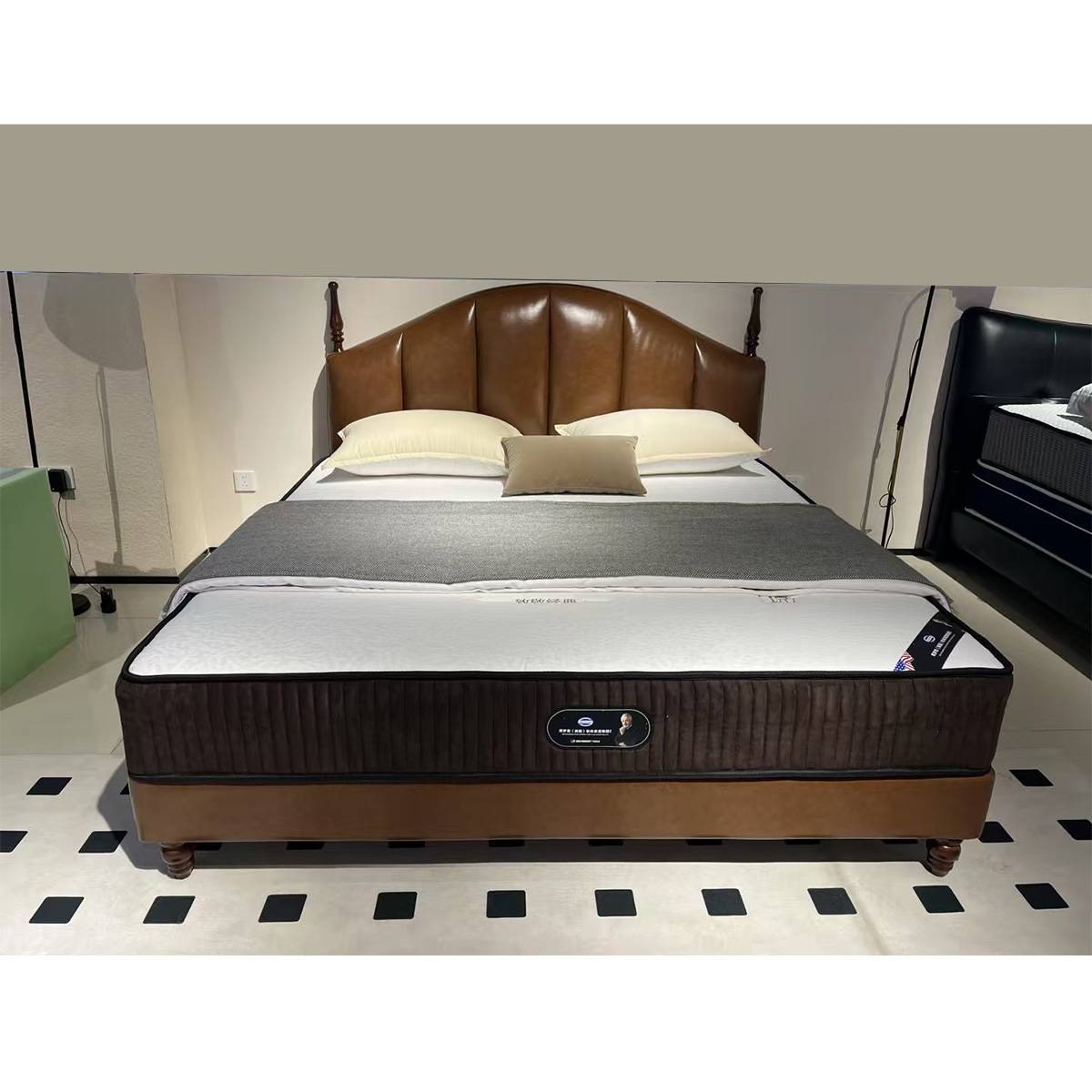 Full view of the brown leather mid-century bed with white bedding and grey throw