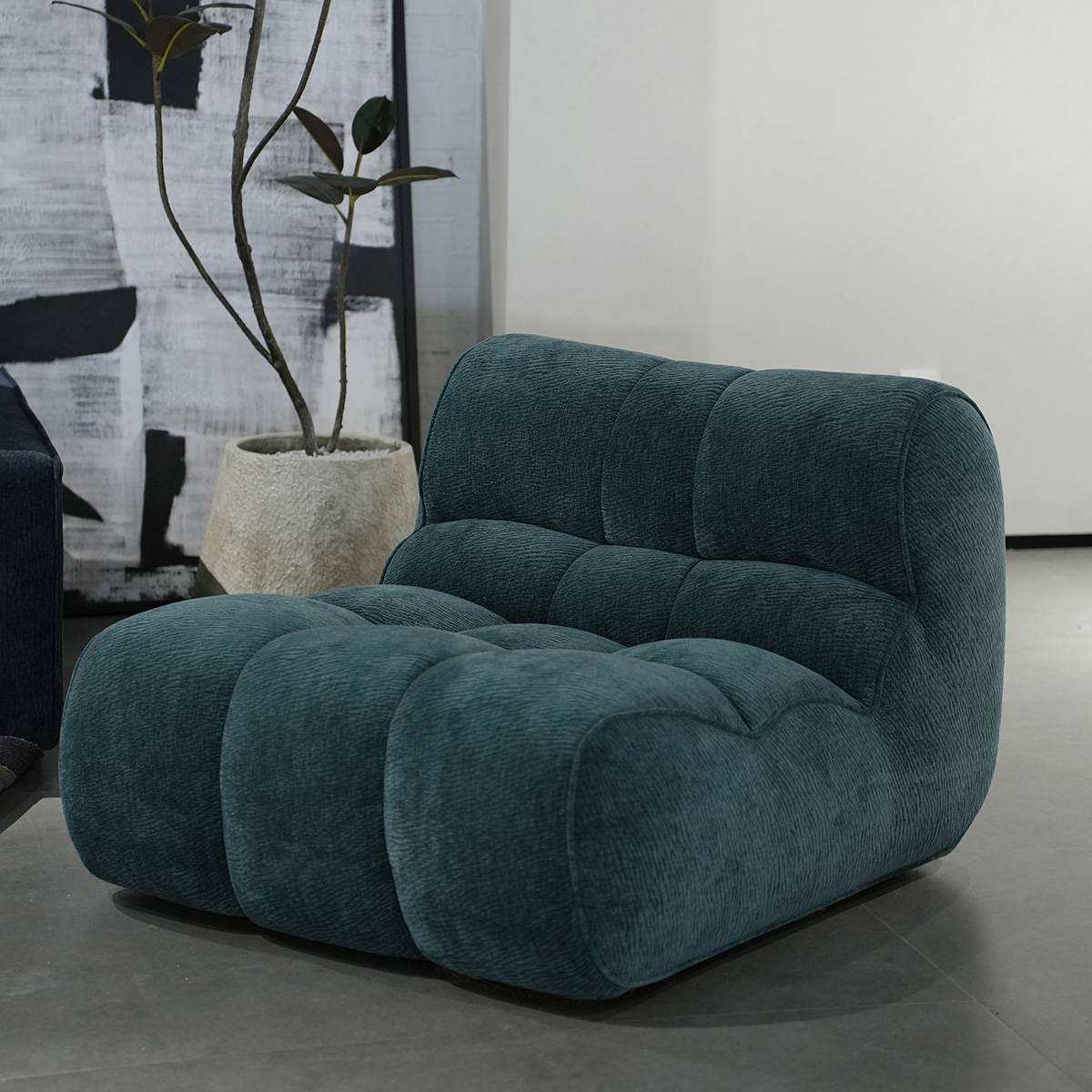 Teal lounge chair in a modern living room setting with plant