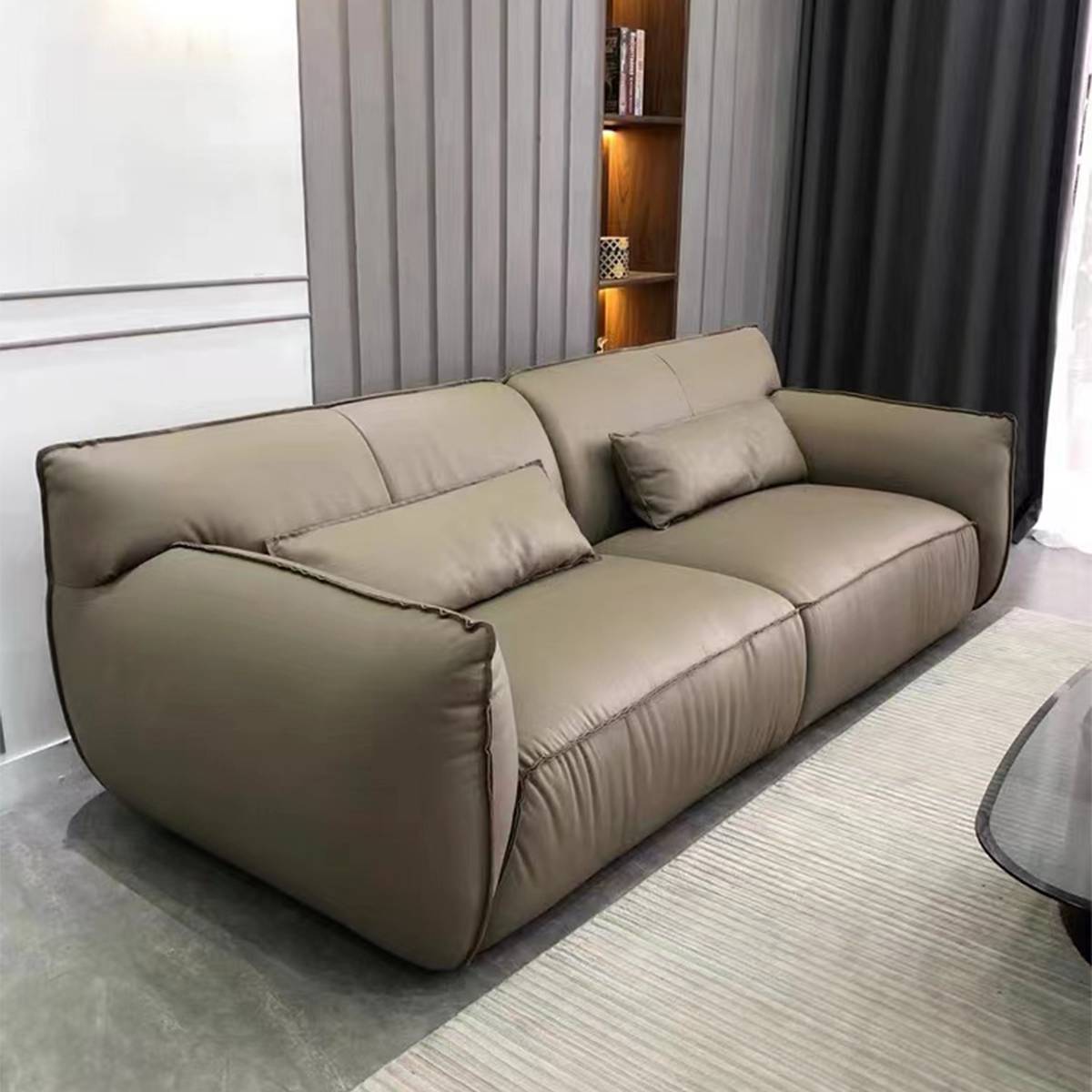 Front angle view of the beige leather sofa in a modern living room setting