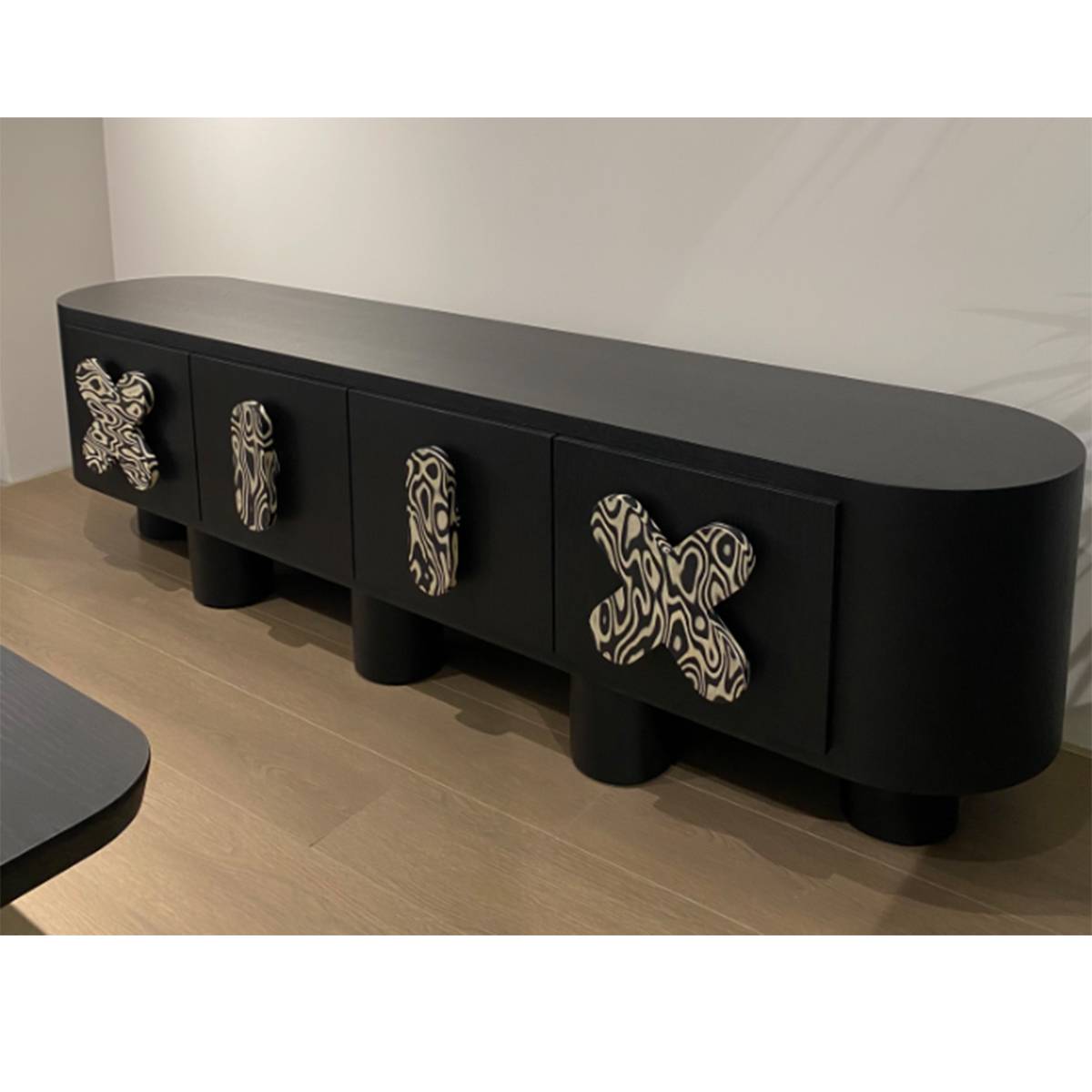 Angled view of the black sideboard showing the rounded edges and drawer details