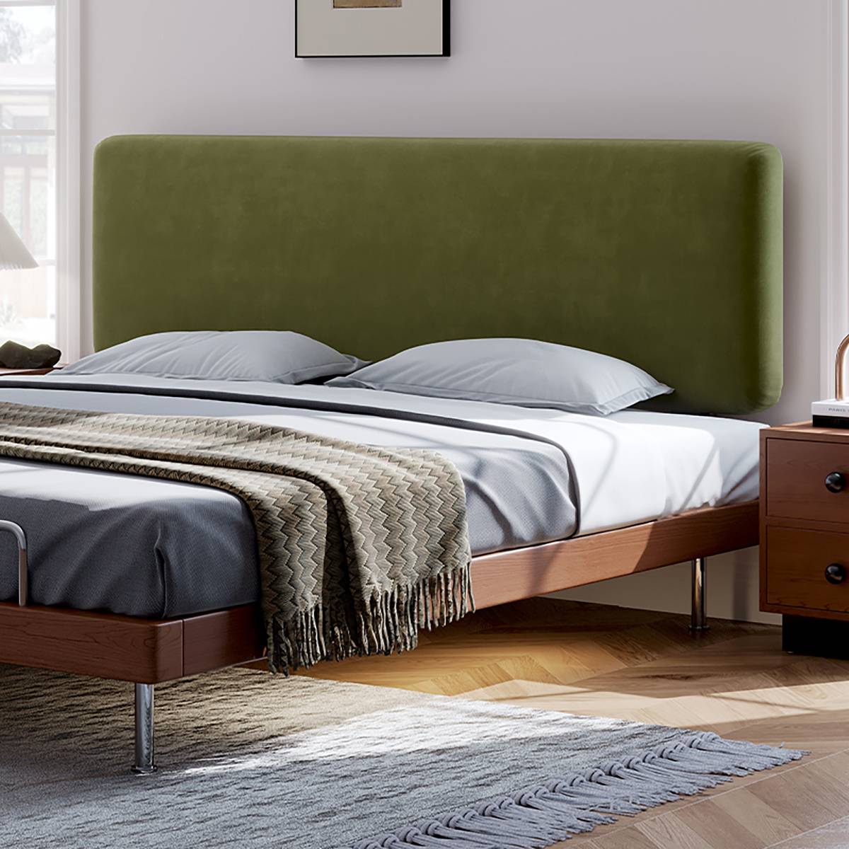 Close-up of the green velvet headboard and wooden bed frame