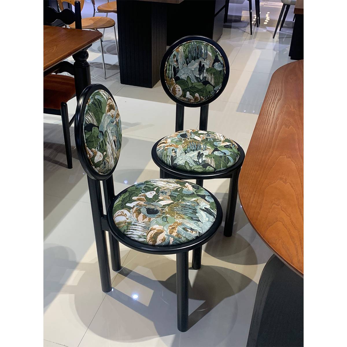 Two mid-century sun chairs with patterned upholstery in a showroom setting