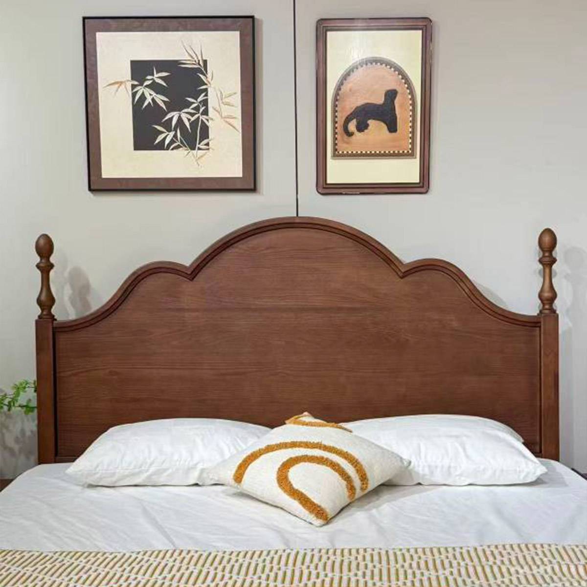 Mid-century solid wood bed with curved headboard and white bedding