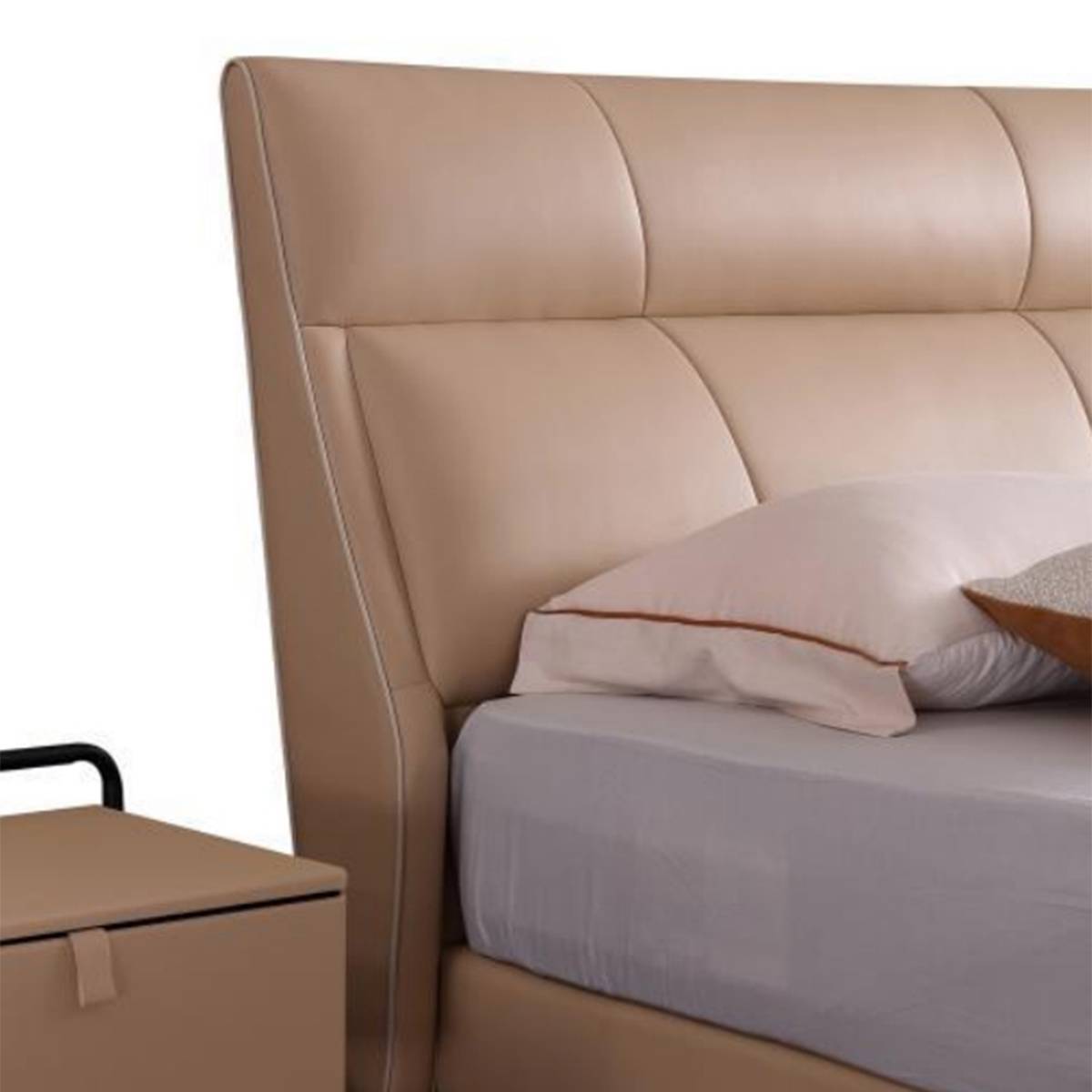Close-up of a beige leather bed headboard with tufted design and pillows