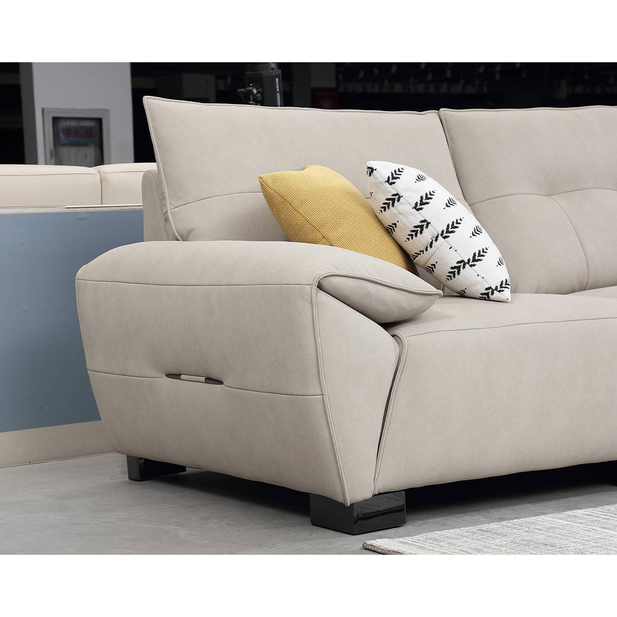 Close-up detail of the sofa armrest and side profile, highlighting the fabric texture and black wooden legs.