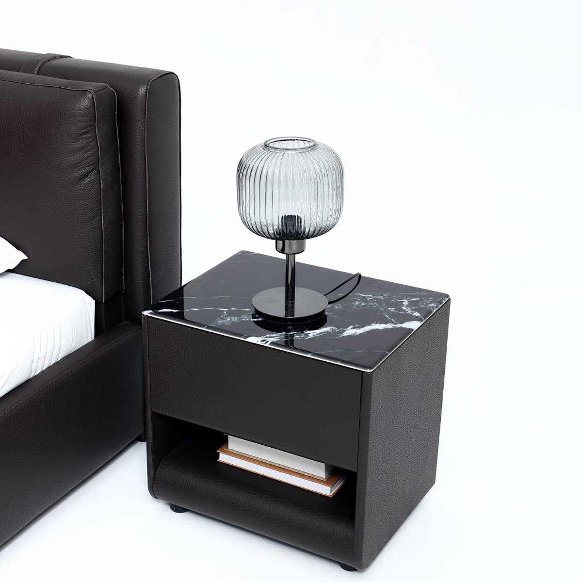 Close-up of the matching bedside table with black marble top and glass lamp