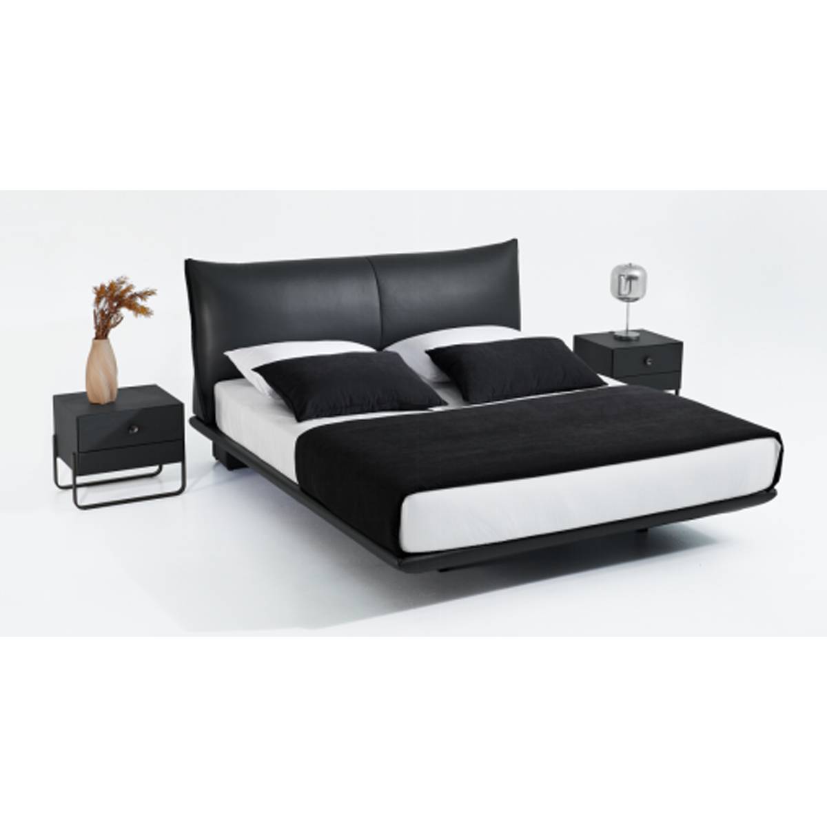 Full view of the black leather floating bed with white bedding and black throw