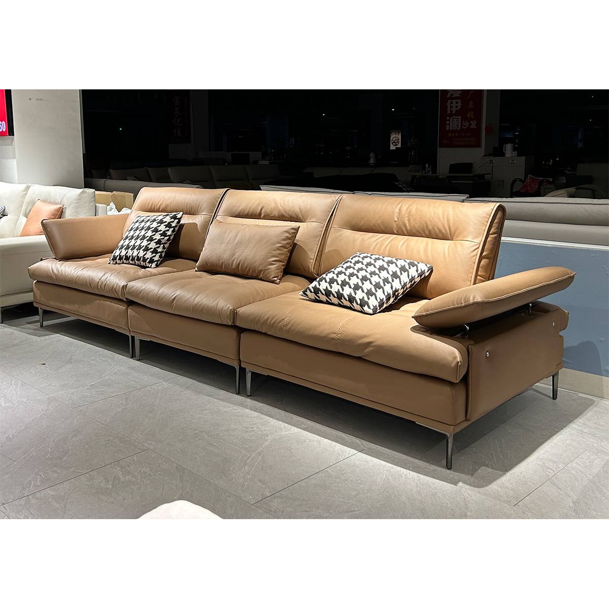 Front three-quarter view of the brown leather sofa in a showroom setting