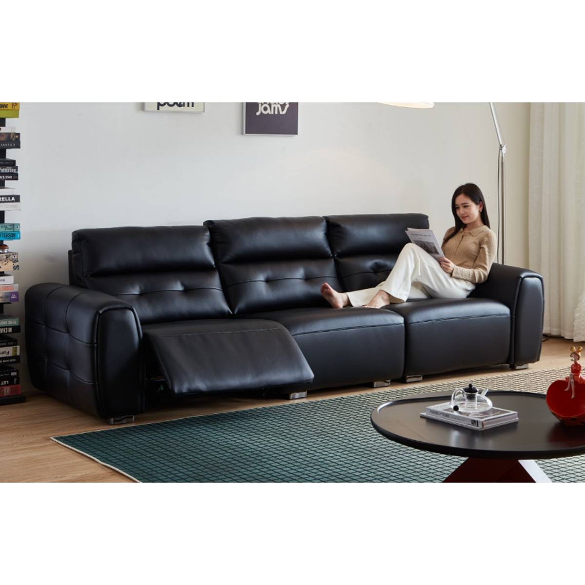 Woman reading on the black leather sofa with one seat reclined