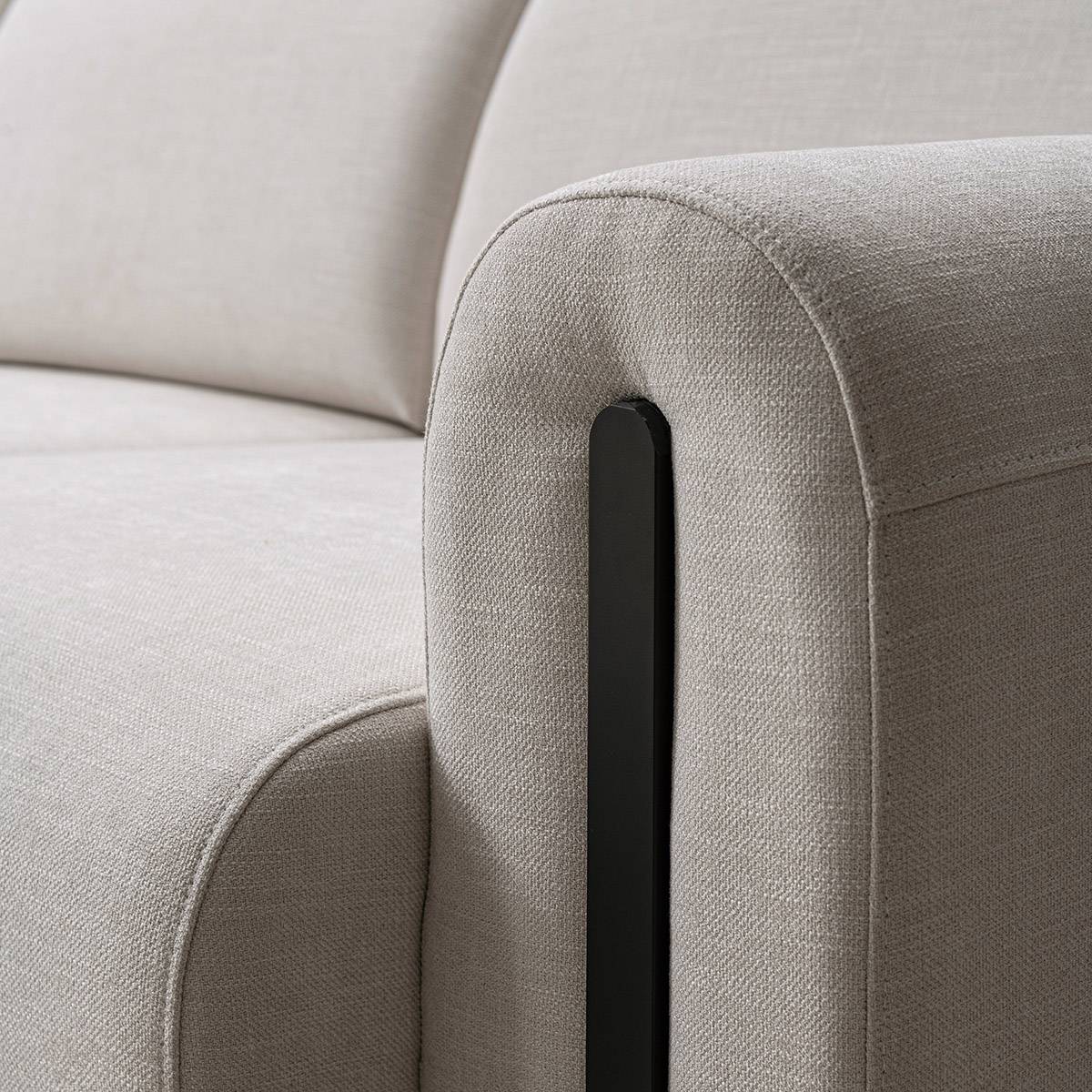 Close-up detail of the sofa armrest showing the black vertical accent and fabric stitching.