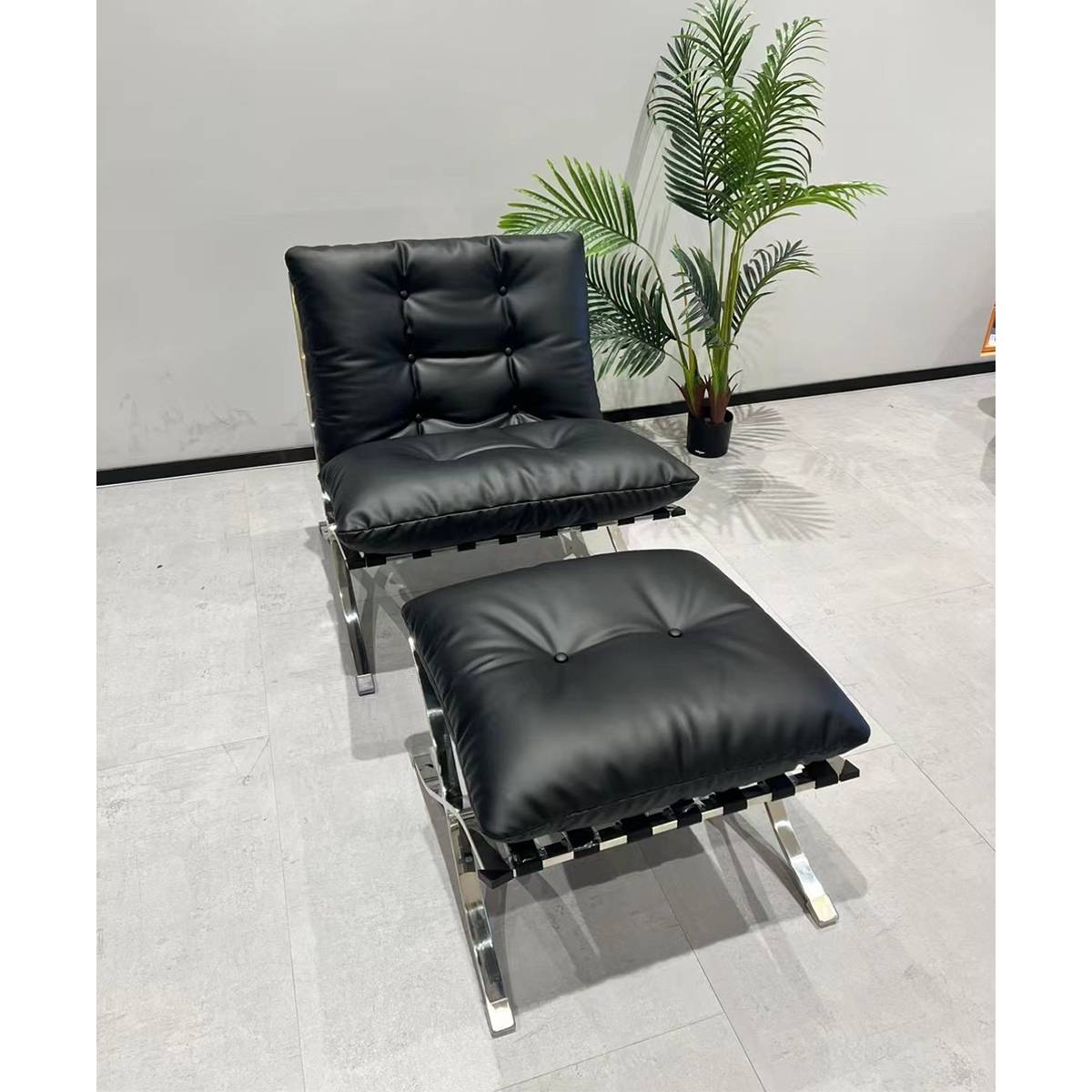 Angled view of black leather lounge chair and ottoman set