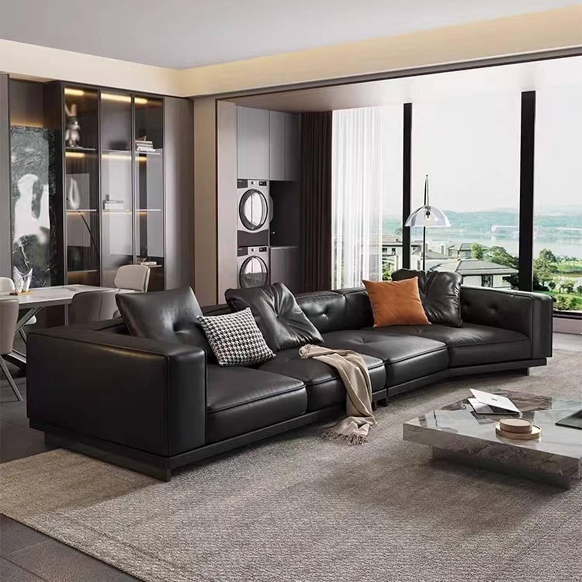 Wide angle view of the black leather sofa in a luxury apartment setting