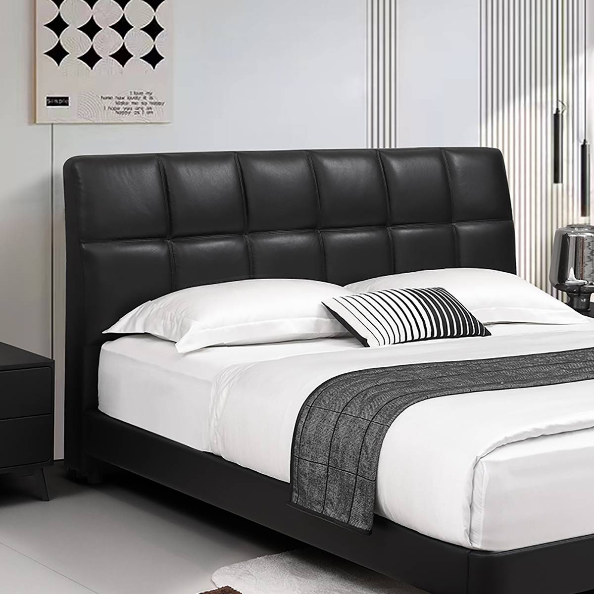 Close-up of the tufted black leather headboard and pillows