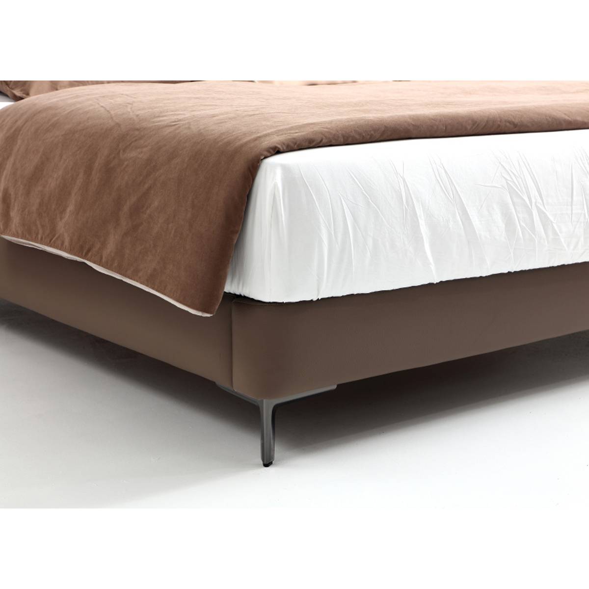 Close-up detail of the bed base showing the metal legs and leather upholstery