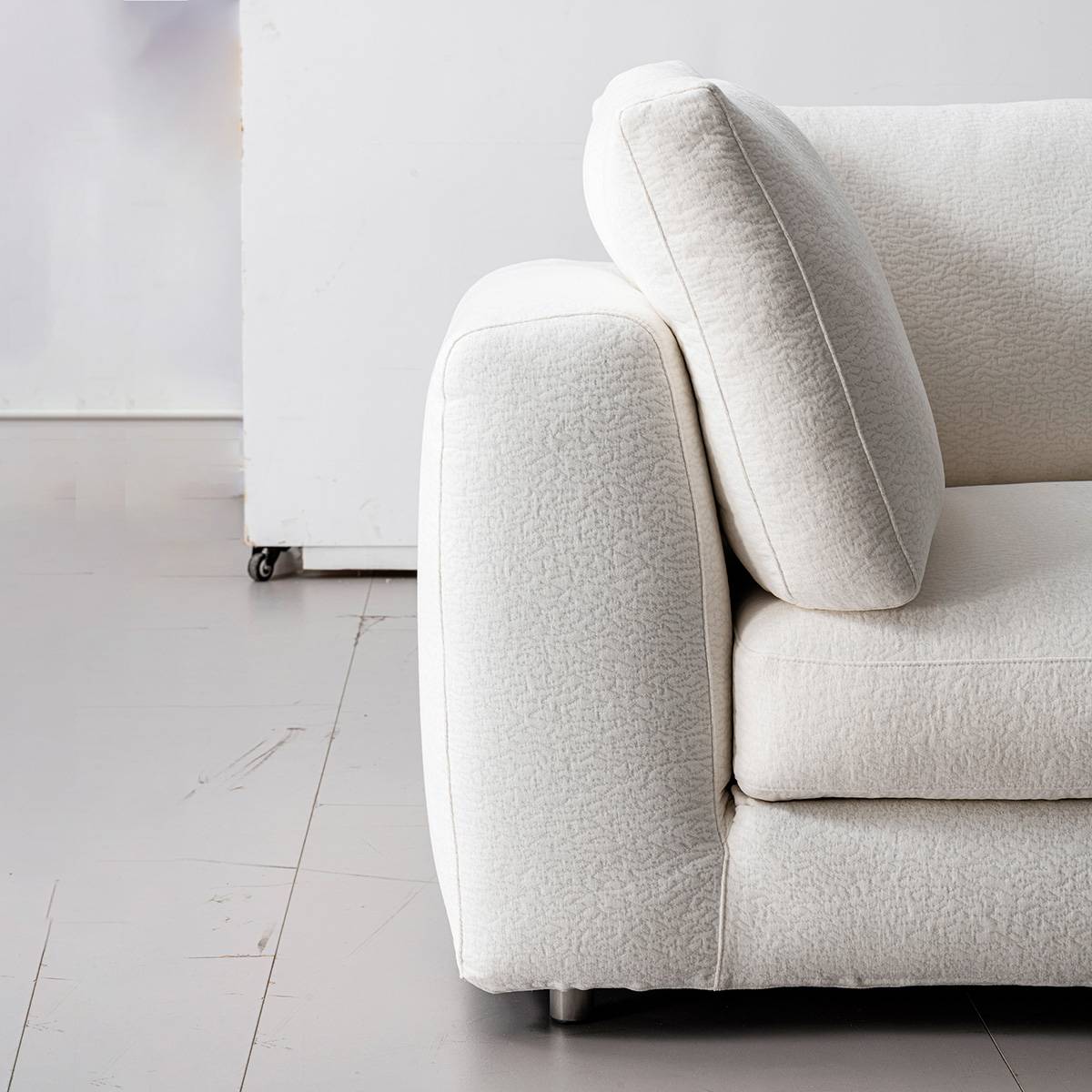 Close-up of the sofa armrest and back cushion showing fabric texture