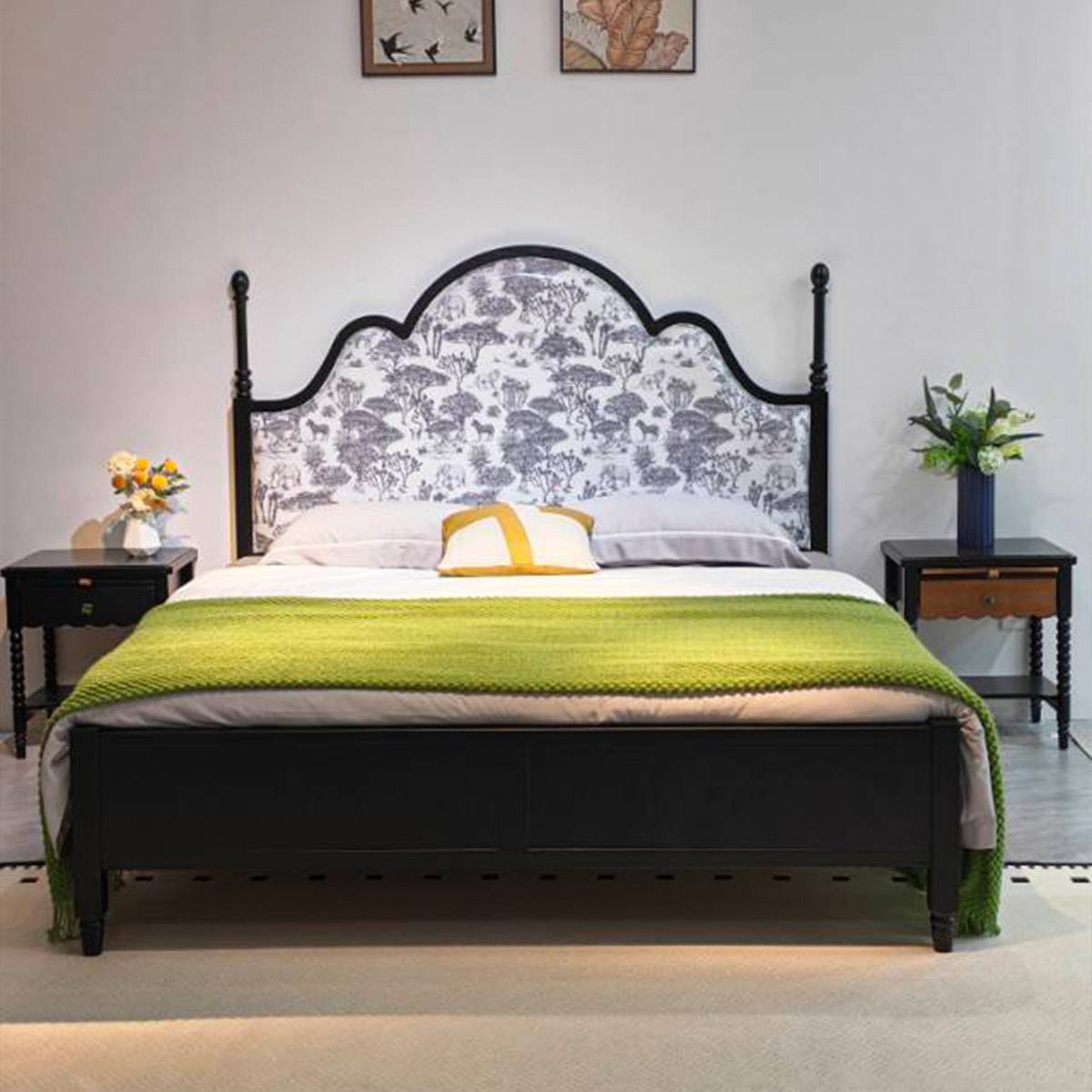 Front view of the bed with green throw blanket and matching nightstands