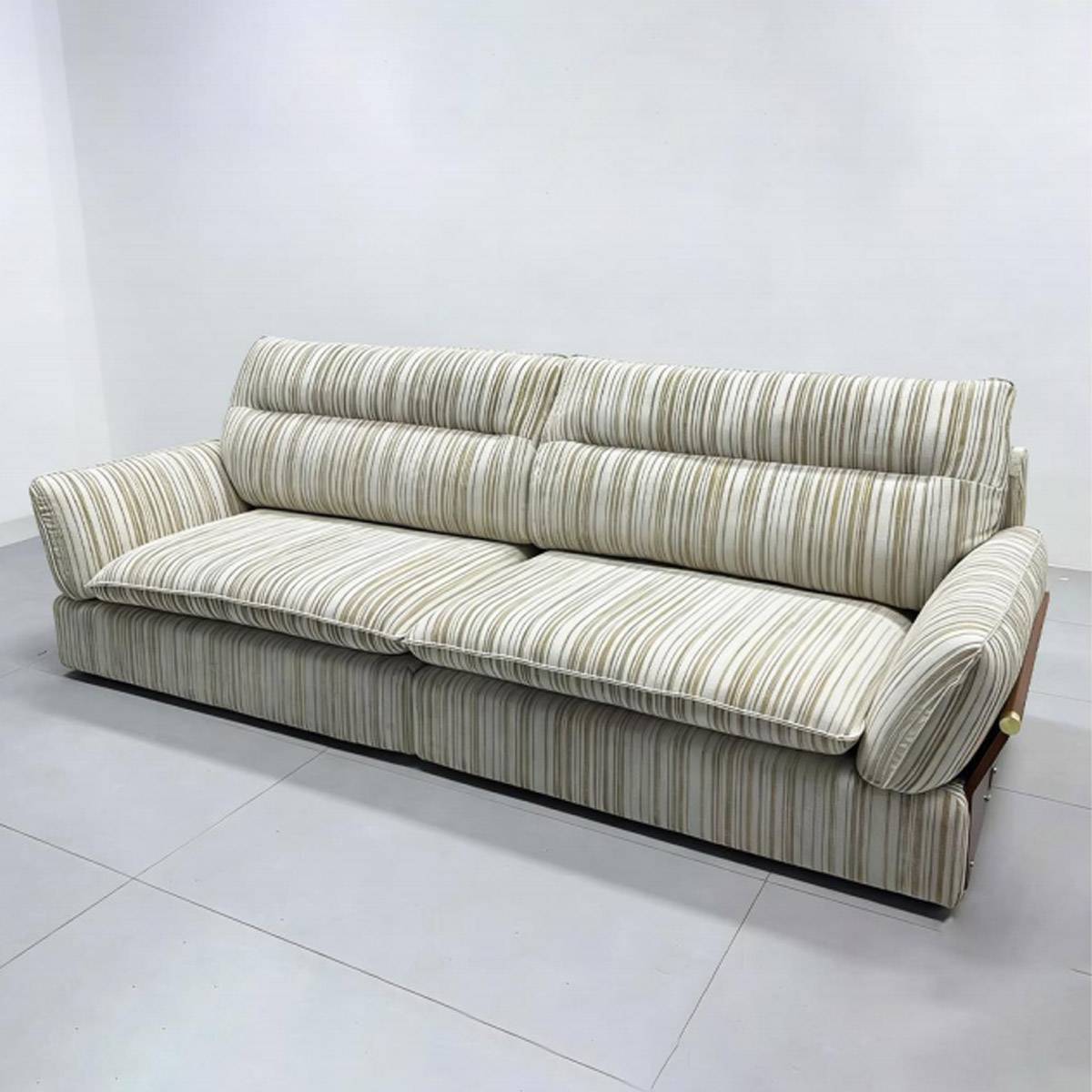 Three-quarter view of the striped fabric sofa showing the wooden frame and steel legs.