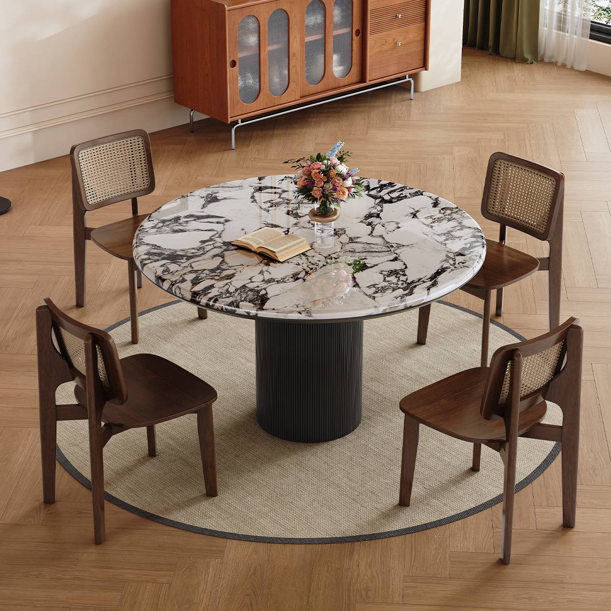 Round marble dining table with black fluted base and wooden cane chairs