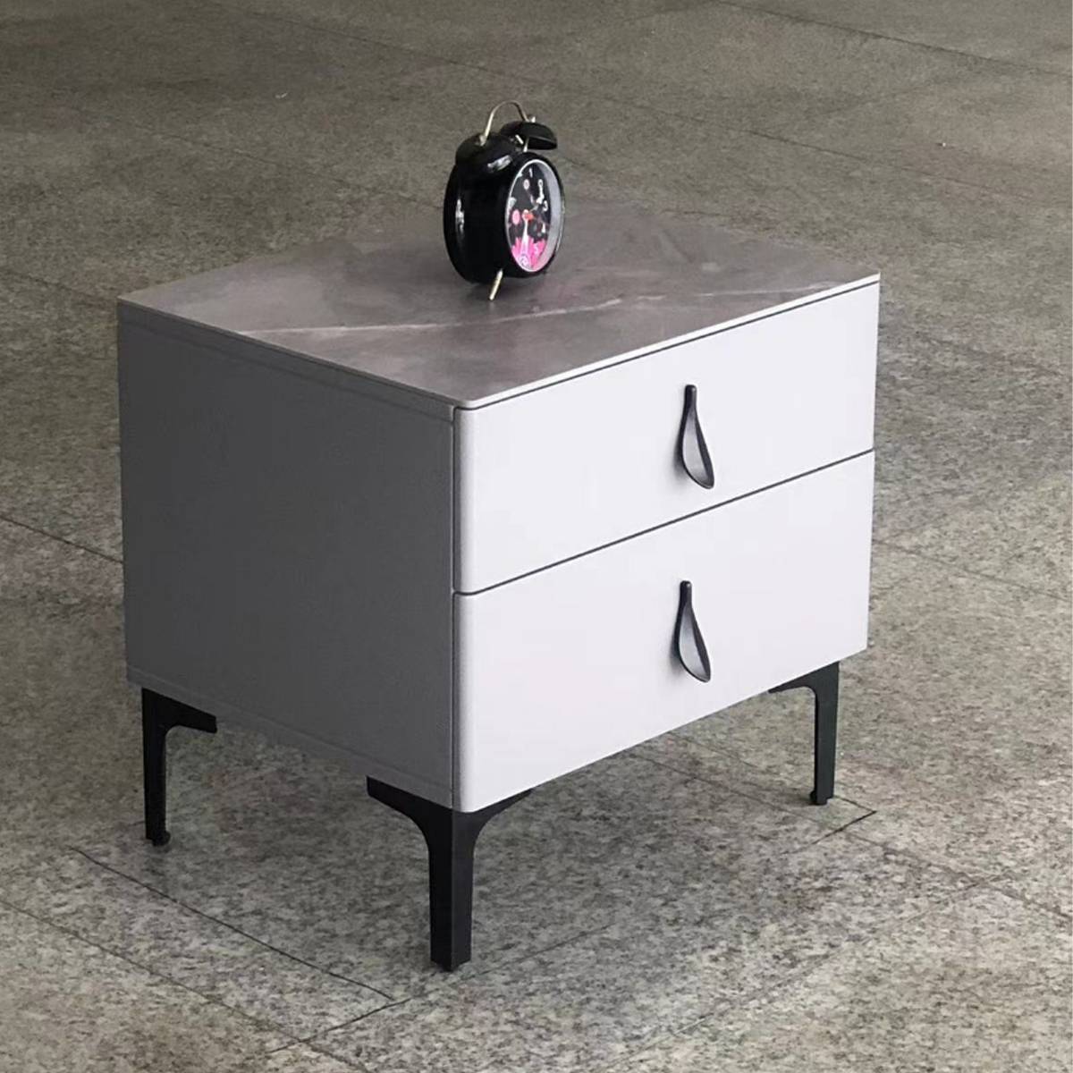 Angled view of the grey bedside table with an alarm clock on top