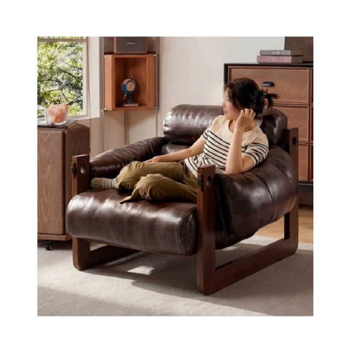 Person relaxing on the brown leather lounge chair